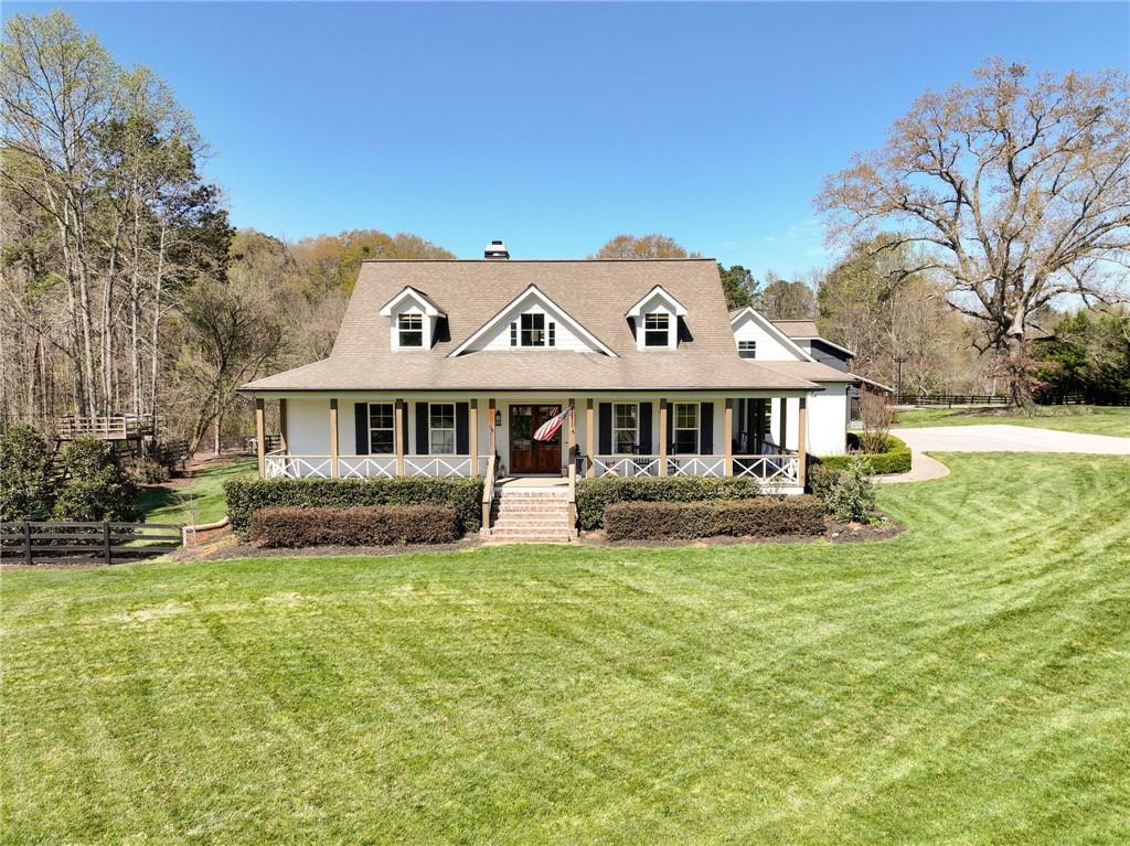 7093 Vaughn Road Woodstock, GA 30188 - Photo 8 of 86 a front view of a house with a garden and yard
