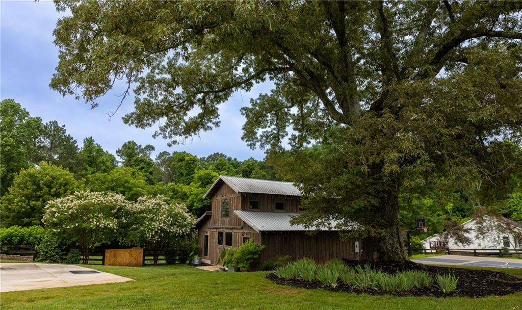 7093 Vaughn Road Woodstock, GA 30188 - Photo 81 of 86 a view of a house with a yard and potted plants