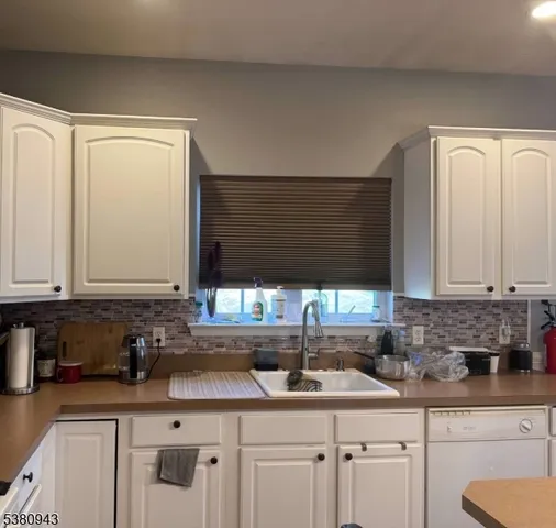 a kitchen with a sink a stove a refrigerator and cabinets