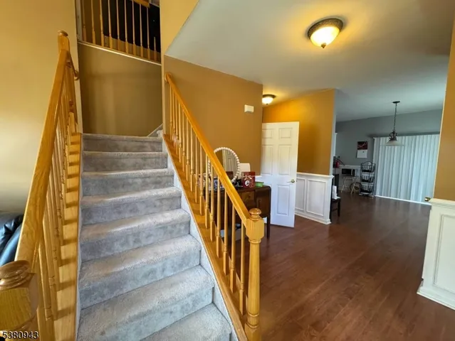 a view of a hallway with wooden floor and staircase