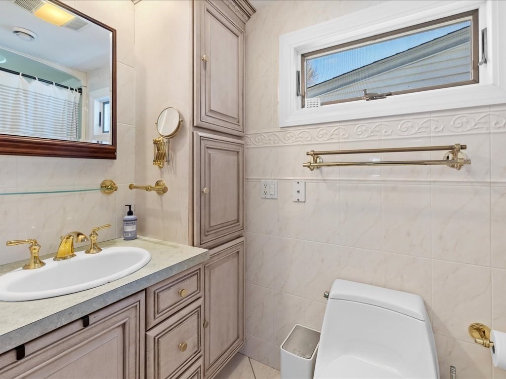 39 Broad Meadow Road Needham, MA 02492 - Photo 24 of 36 a bathroom with a sink a toilet and mirror
