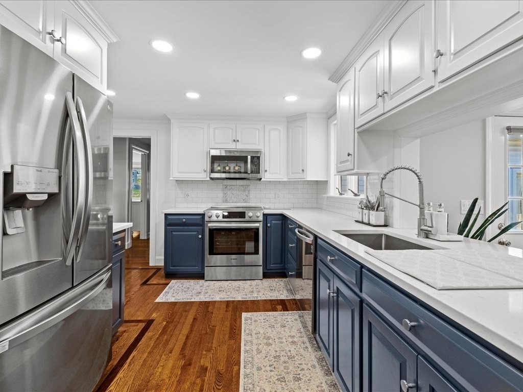 39 Broad Meadow Road Needham, MA 02492 - Photo 5 of 36 a large kitchen with stainless steel appliances granite countertop a sink a stove and a refrigerator