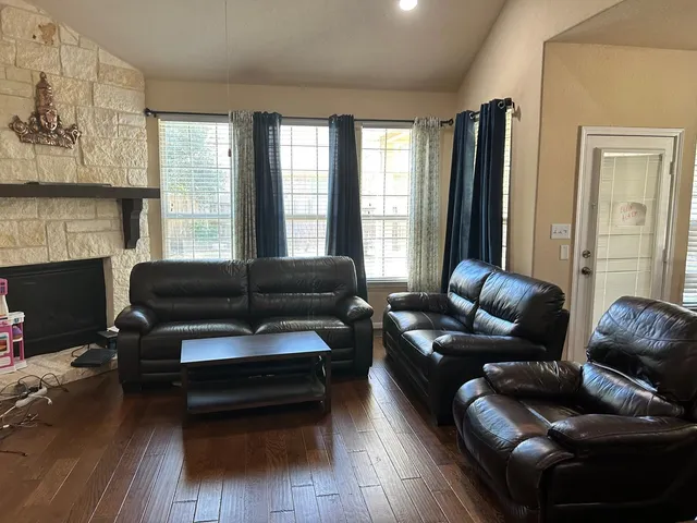 a living room with furniture a fireplace and a large window