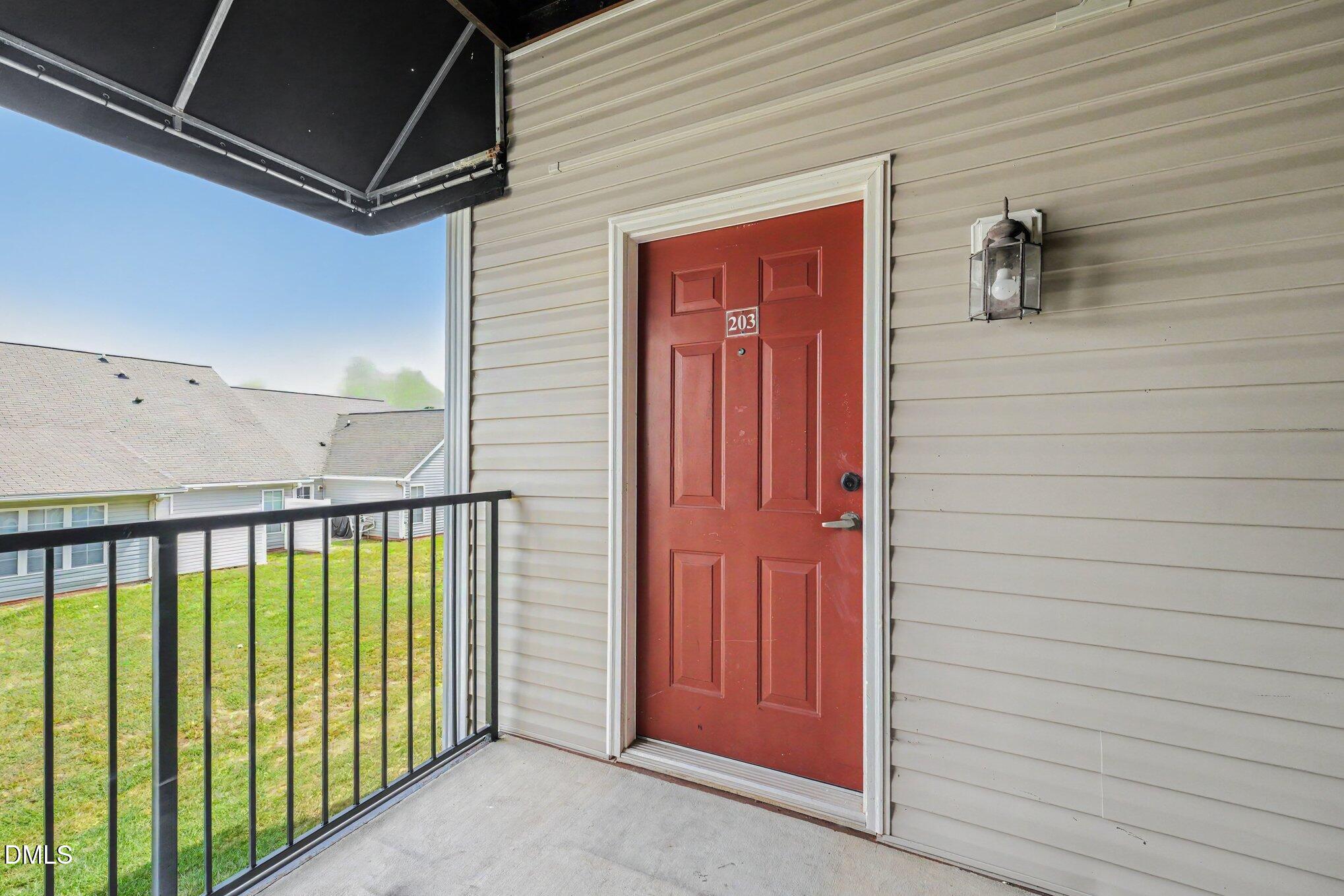 2521 Friedland Place Raleigh, NC 27617 - Photo 3 of 21 Covered entry landing equipped with an overhead awning canopy and exterior sconce, providing extra weather shielding and a cozy, private arrival alcove.