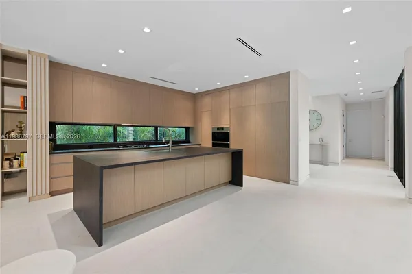 a large white kitchen with a large window
