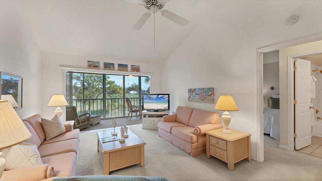 450 Cerromar Road, Unit 282 Venice, FL 34293 - Photo 5 of 44 a living room with furniture and a floor to ceiling window