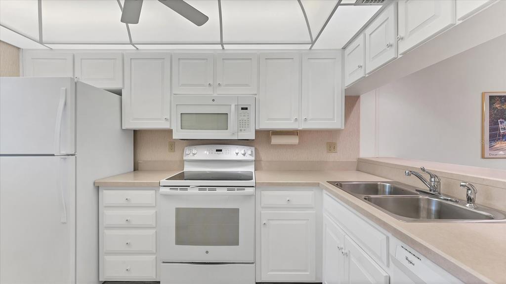 450 Cerromar Road, Unit 282 Venice, FL 34293 - Photo 10 of 44 a kitchen with cabinets appliances a sink and a counter top