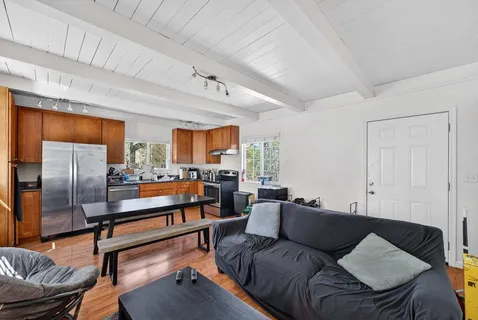 a kitchen with stainless steel appliances granite countertop a stove a refrigerator a kitchen island a table and chairs in it