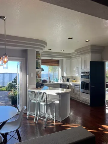 a kitchen with stainless steel appliances granite countertop a table and chairs in it