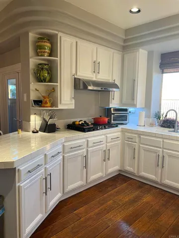 a kitchen with granite countertop white cabinets and white appliances