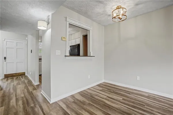 a view of a room with wooden floor and a hallway