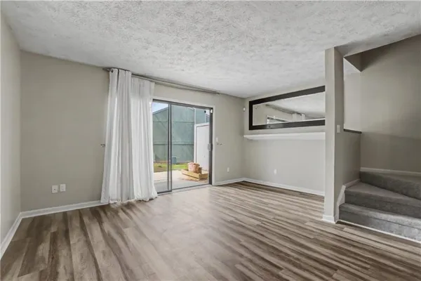 a view of an empty room with glass door and a window