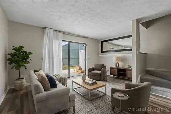 a living room with furniture plant and a large window