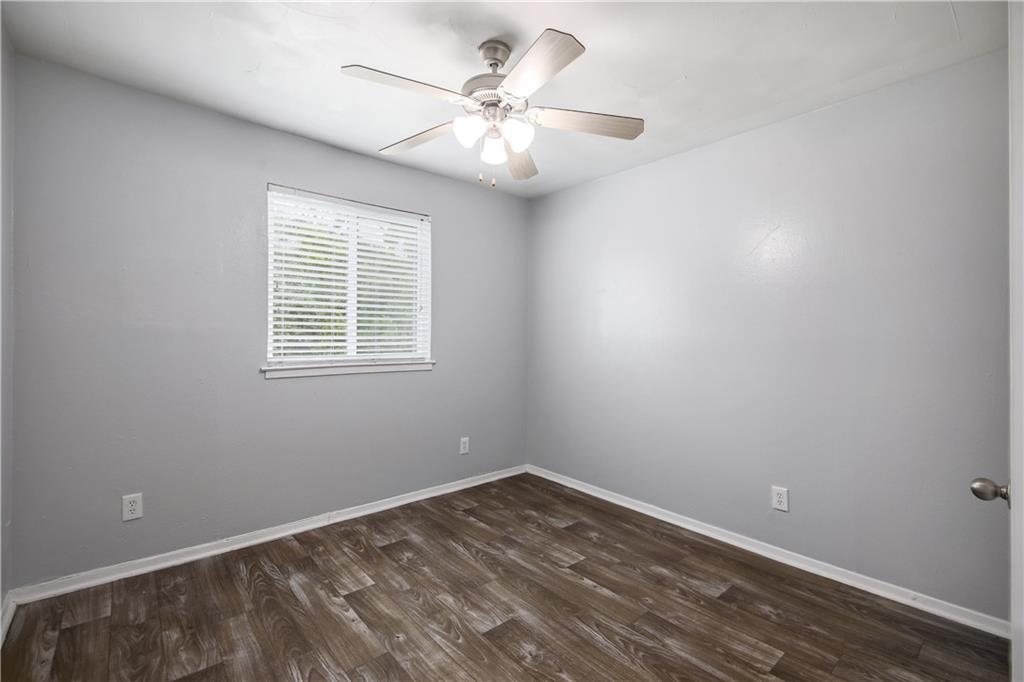 2401 Manor Road, Unit 102 Austin, TX 78722 - Photo 21 of 22 Empty room featuring dark wood finished floors and ceiling fan