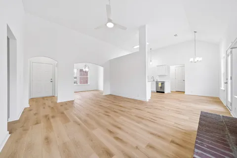 a view of empty room with wooden floor