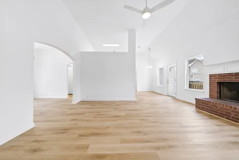 a view of empty room with wooden floor and fireplace