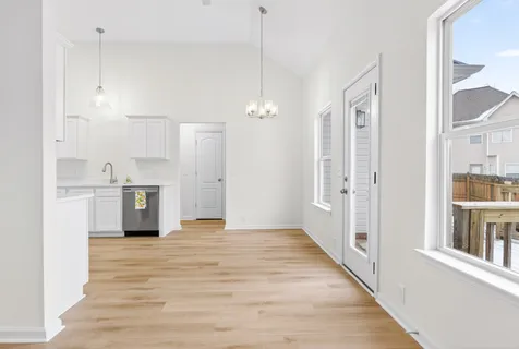 a view of a kitchen with refrigerator and wooden floor
