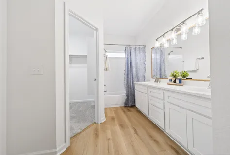 a bathroom with a tub sink and mirror