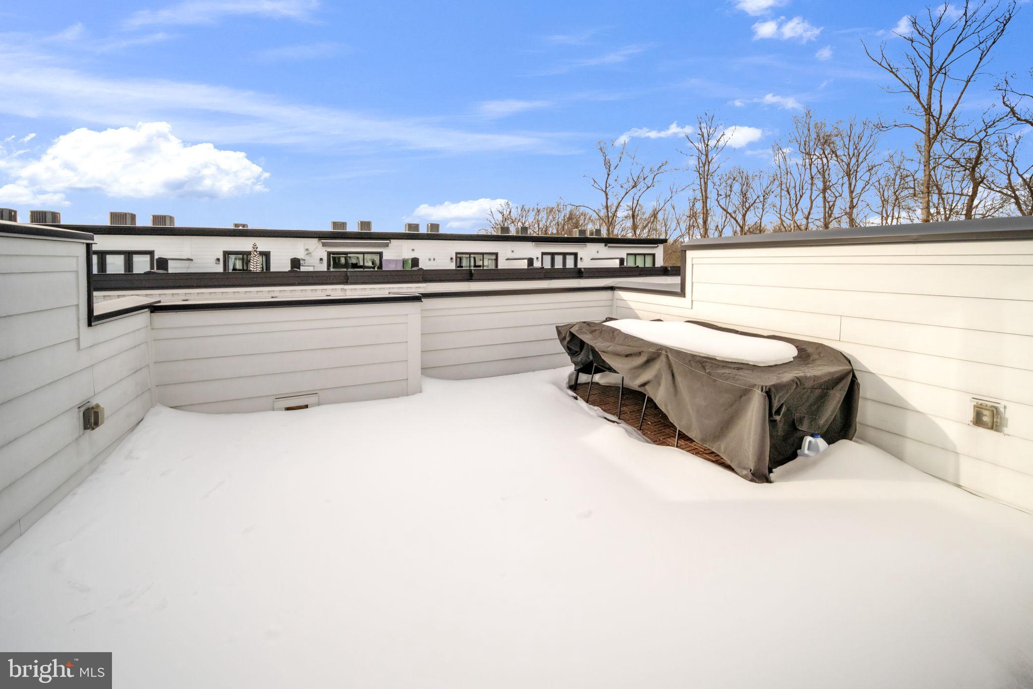 11326 Emerald Park Road Potomac, MD 20854 - Photo 27 of 40 Snow-covered rooftop retreat under blue skies.
