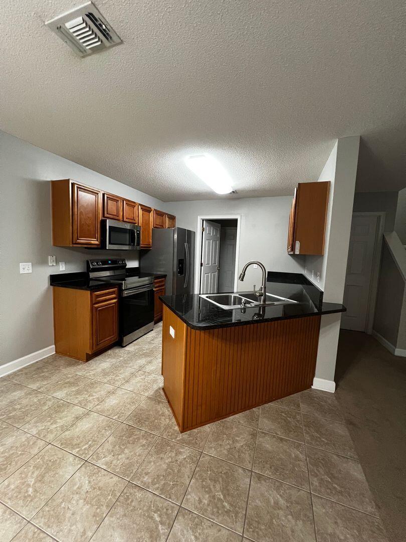 23 3rd Street Shalimar, FL 32579 - Photo 7 of 15 a living room with furniture a kitchen island a stove and a refrigerator