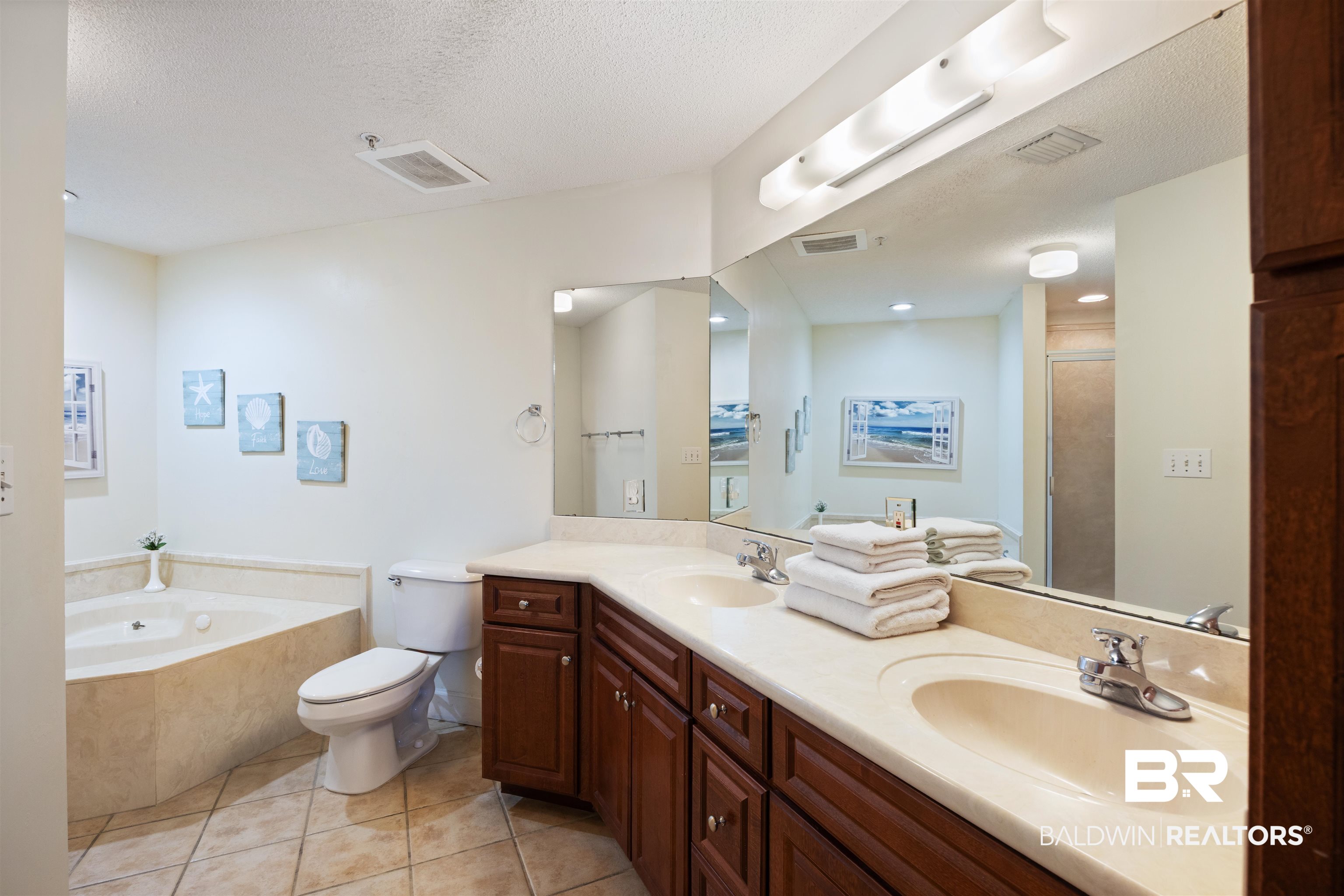 27580 Canal Road, Unit 1431 Orange Beach, AL 36561 - Photo 24 of 73 Bathroom featuring double vanity, a bath, light tile patterned floors, a textured ceiling, and a stall shower