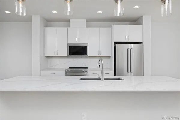a kitchen with stainless steel appliances a sink a stove a microwave and cabinets