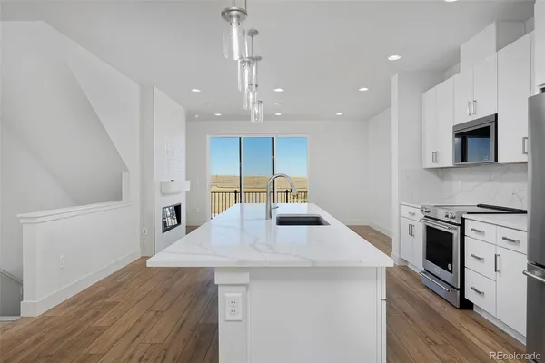 a kitchen with stainless steel appliances a stove top oven a sink and a refrigerator