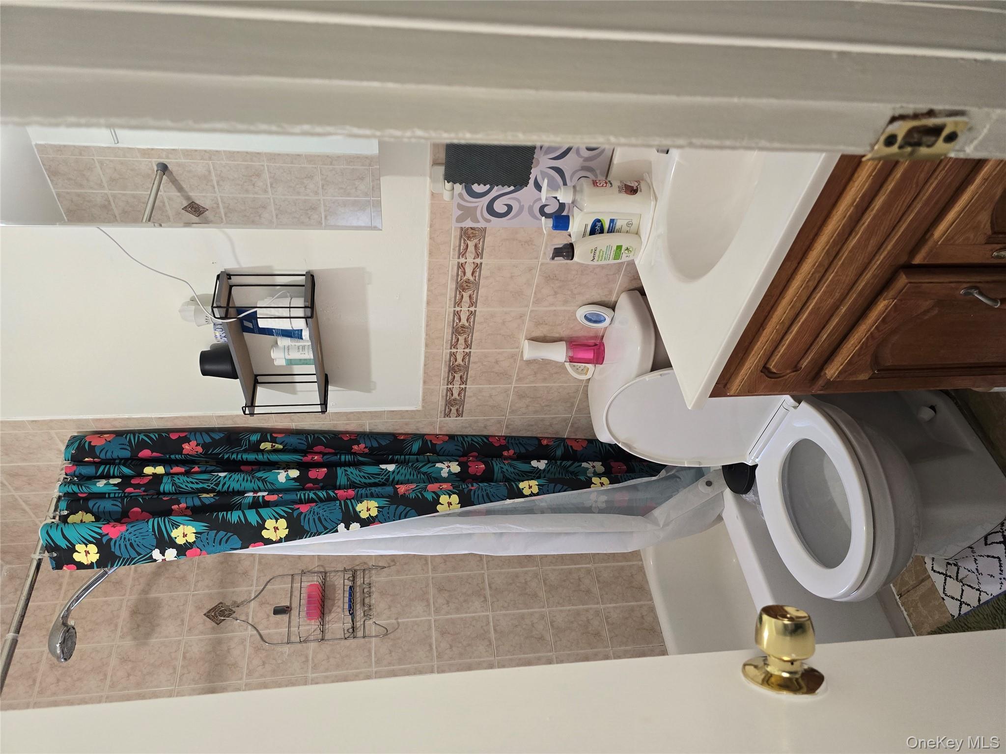 116-33 134th Street Queens, NY 11420 - Photo 11 of 13 Bathroom with vanity, shower / bath combination with curtain, and tile walls