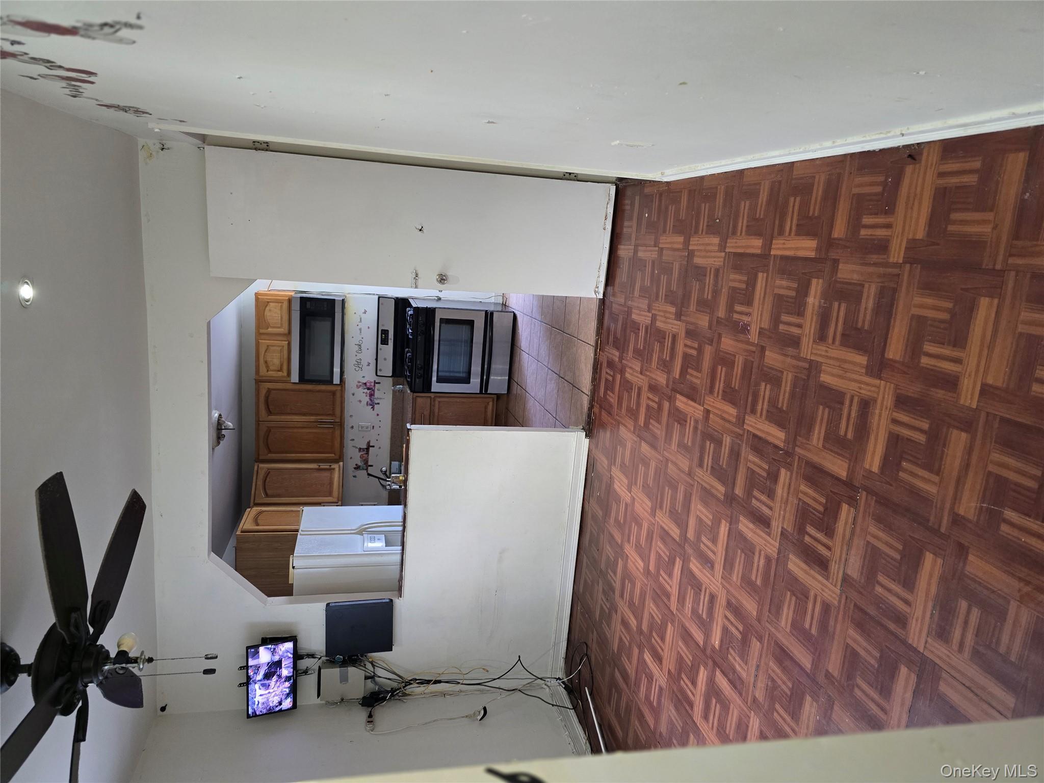 116-33 134th Street Queens, NY 11420 - Photo 6 of 13 Kitchen featuring brown cabinetry, stove, refrigerator, white microwave, and ceiling fan