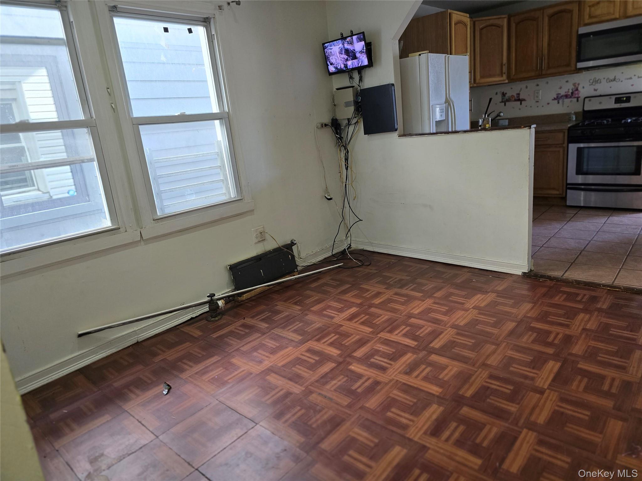 116-33 134th Street Queens, NY 11420 - Photo 7 of 13 Kitchen featuring stainless steel appliances, brown cabinetry, and dark tile patterned flooring