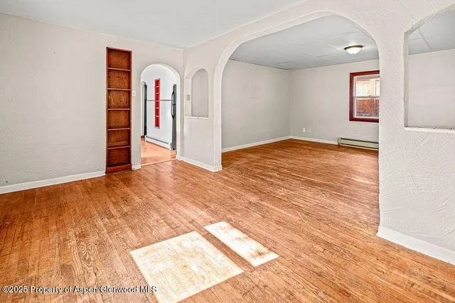 a view of empty room with wooden floor