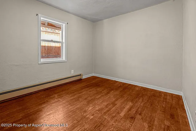 a view of empty room with wooden floor