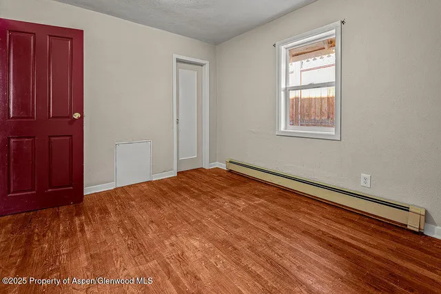a view of empty room with wooden floor