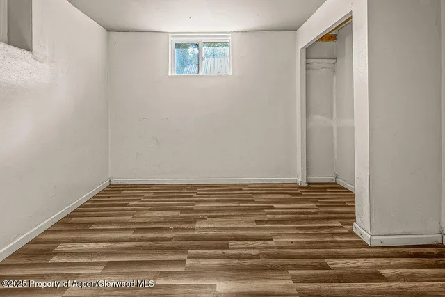 a view of a small space with wooden floor and a window