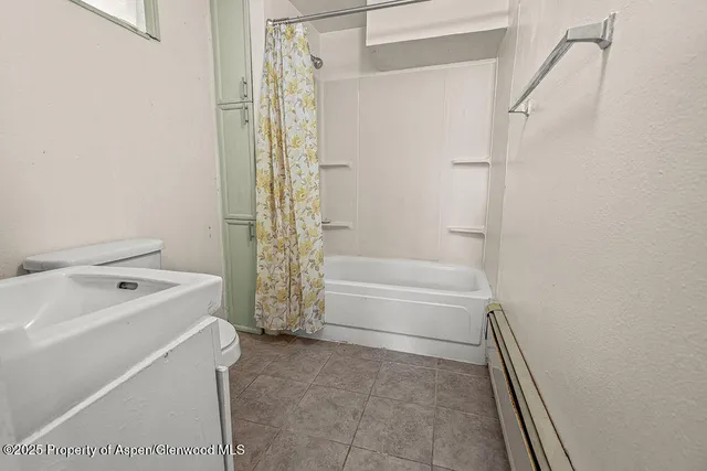 a bathroom with a tub sink and shower