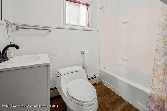 a white toilet sitting next to a bath tub