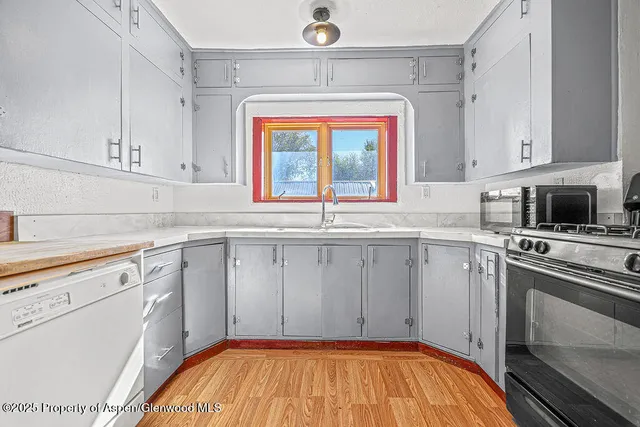 a kitchen with a sink cabinets and a window