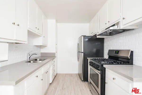 a stove top oven sitting inside of a kitchen