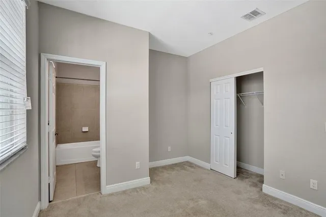an empty room with closet and a bathroom