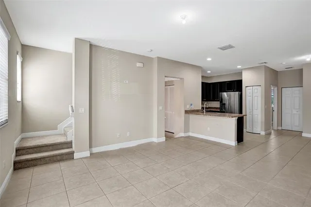 a large white kitchen with a refrigerator a stove and a sink