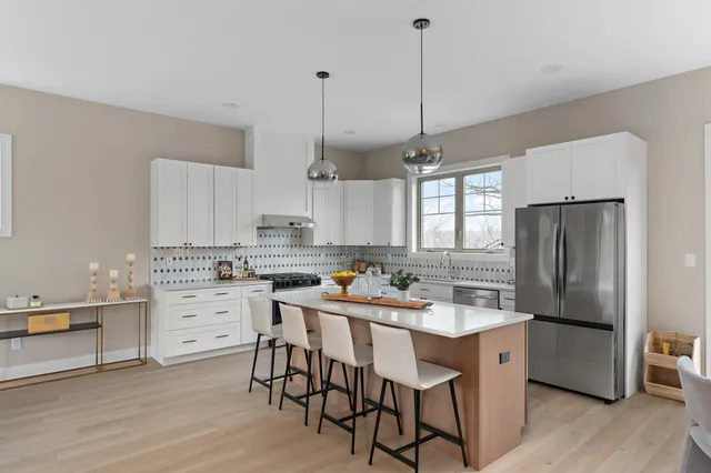 a kitchen with white cabinets and stainless steel appliances