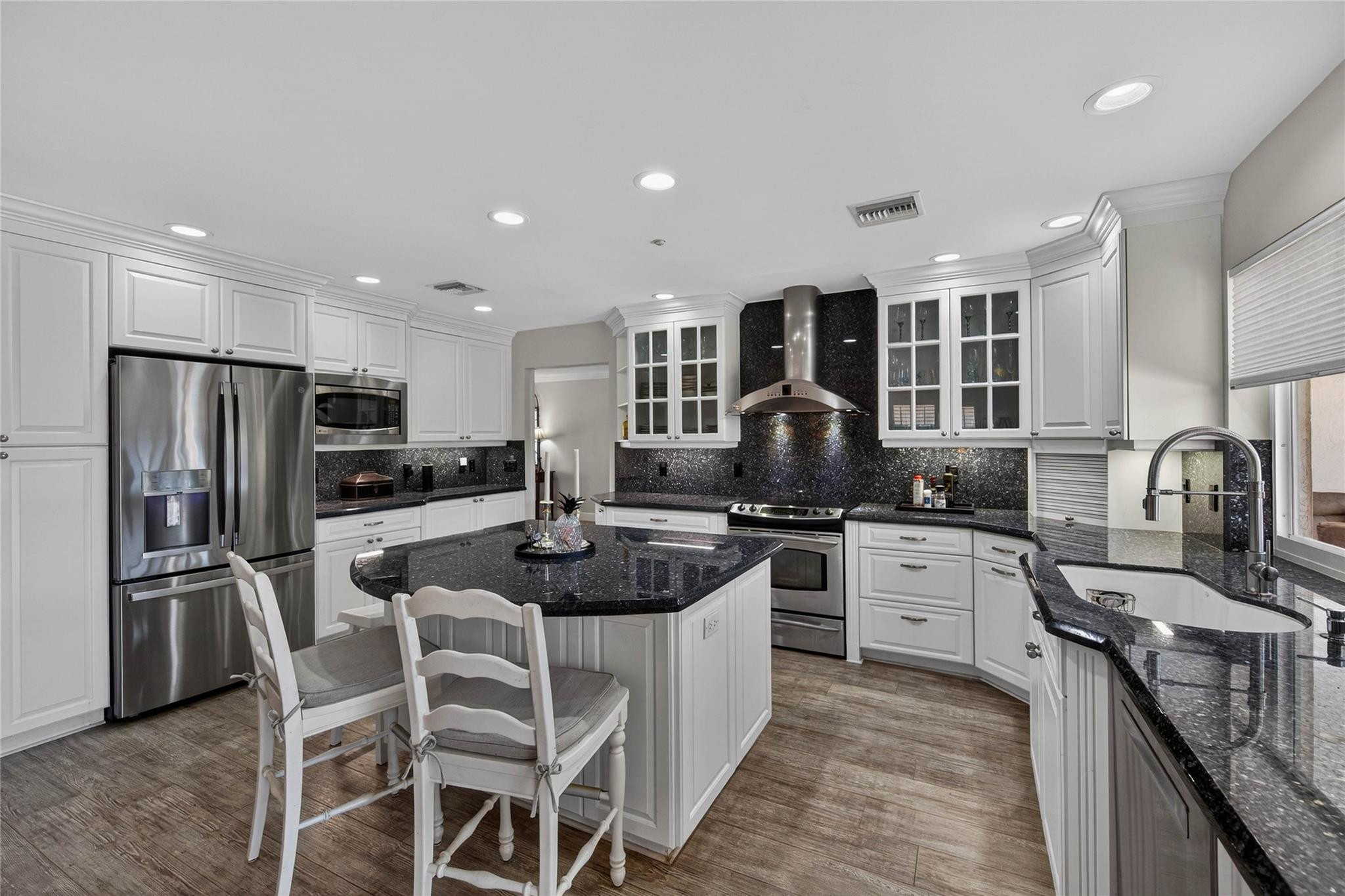 2600 Northeast 46th Street Lighthouse Point, FL 33064 - Photo 15 of 59 a kitchen with stainless steel appliances granite countertop a stove top oven a sink dishwasher a refrigerator and a dining table with white cabinets
