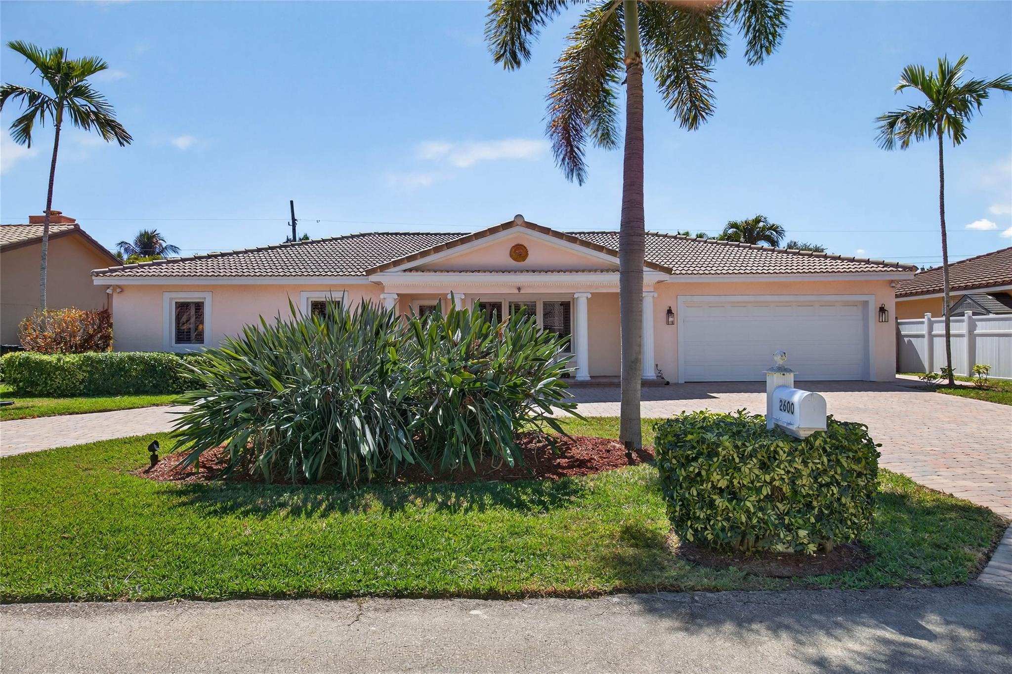 2600 Northeast 46th Street Lighthouse Point, FL 33064 - Photo 36 of 59 a front view of a house with a garden
