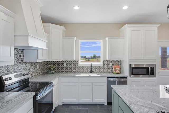 a kitchen with stainless steel appliances granite countertop a sink stove and cabinets