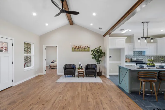 a living room with stainless steel appliances kitchen island furniture and wooden floor