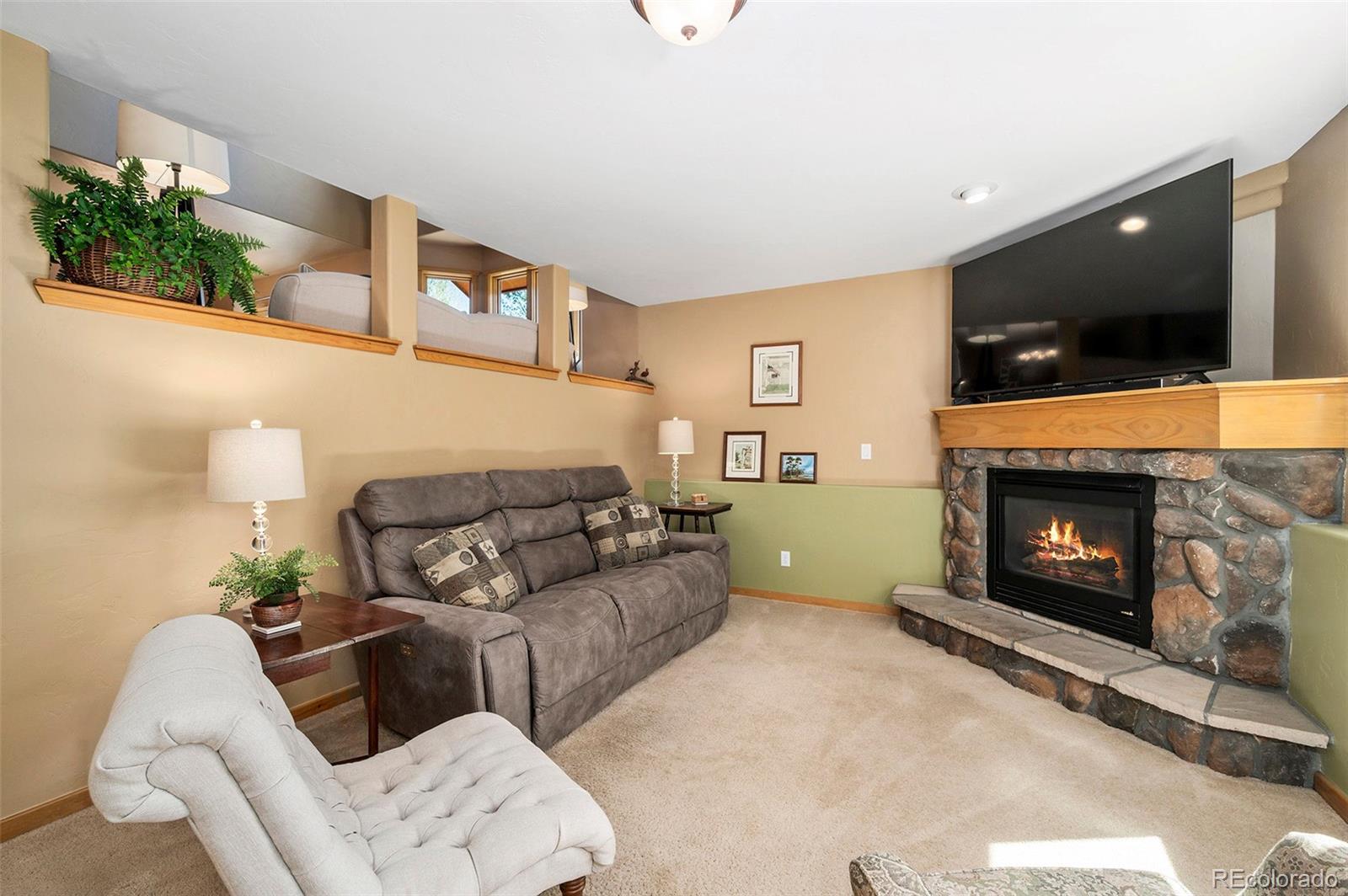 290 Village Road Granby, CO 80446 - Photo 25 of 45 a living room with furniture a flat screen tv and a fireplace
