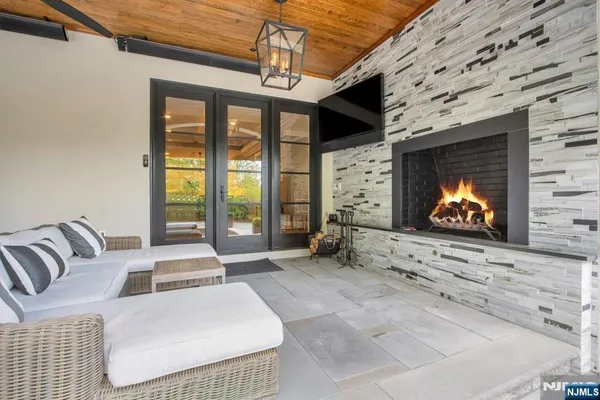 a living room with furniture a flat screen tv and a large window
