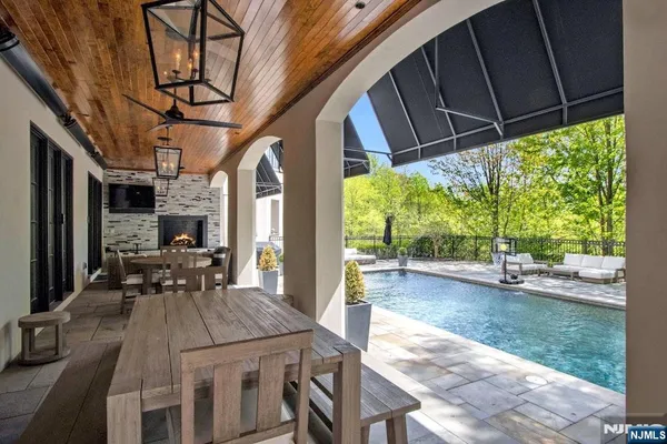 a view of a patio with table and chairs and floor to ceiling window