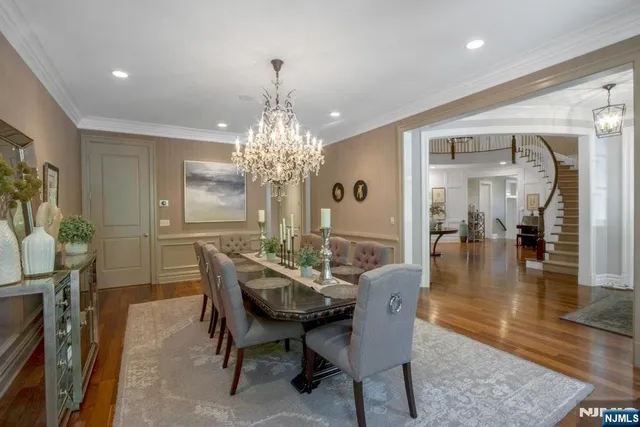 a dining room with furniture a chandelier and wooden floor