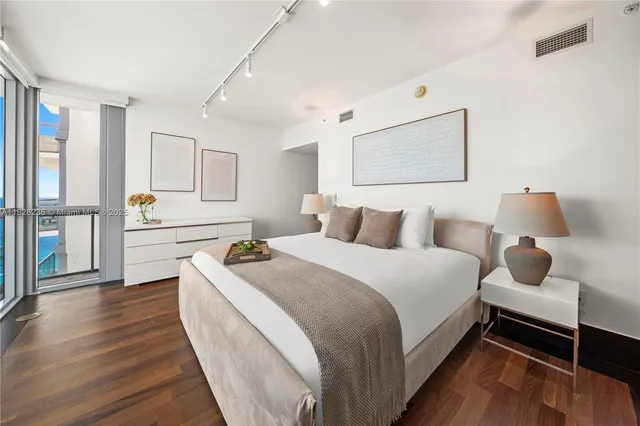 a bedroom with a bed and a large window